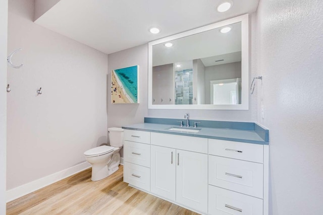 full bath with baseboards, toilet, wood finished floors, vanity, and recessed lighting