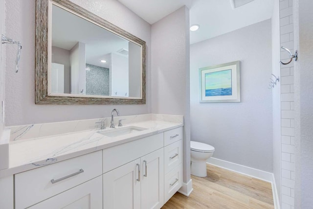 bathroom featuring toilet, wood finished floors, visible vents, vanity, and baseboards