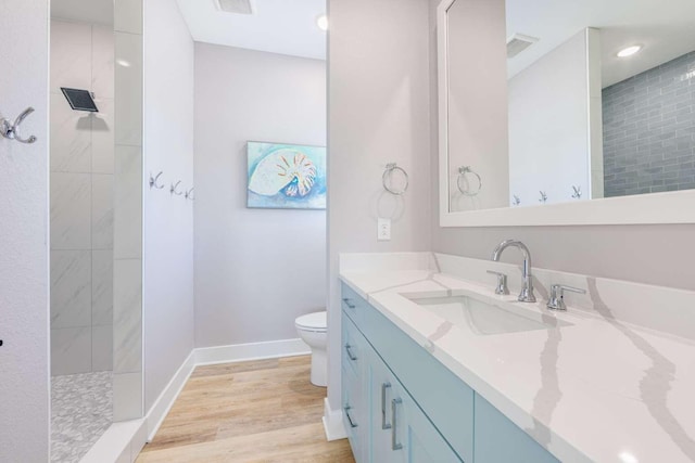 full bath featuring baseboards, visible vents, toilet, wood finished floors, and vanity