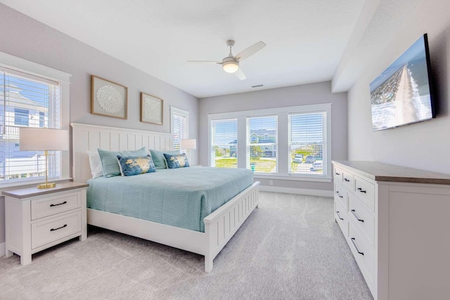 bedroom featuring light carpet, ceiling fan, and baseboards