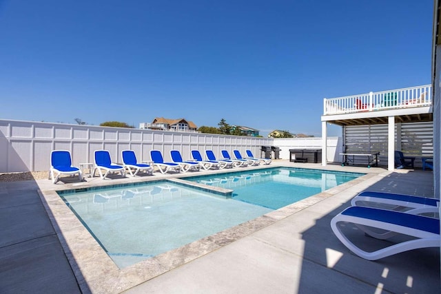 pool with a patio and fence