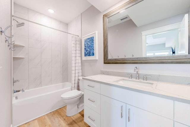 bathroom with shower / tub combo, visible vents, toilet, wood finished floors, and vanity