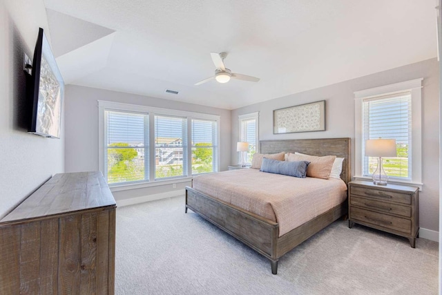 bedroom with baseboards, multiple windows, visible vents, and light colored carpet