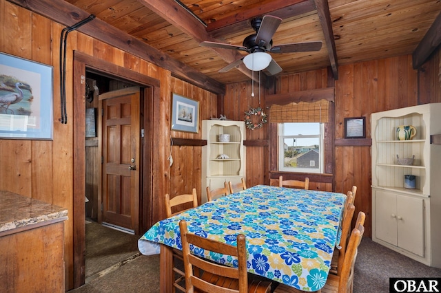 dining space with wood ceiling, wooden walls, and carpet flooring