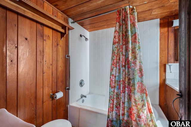 bathroom with toilet, wooden ceiling, wooden walls, and shower / bath combination with curtain