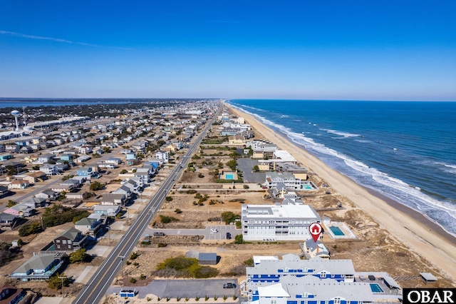 birds eye view of property with a water view and a beach view