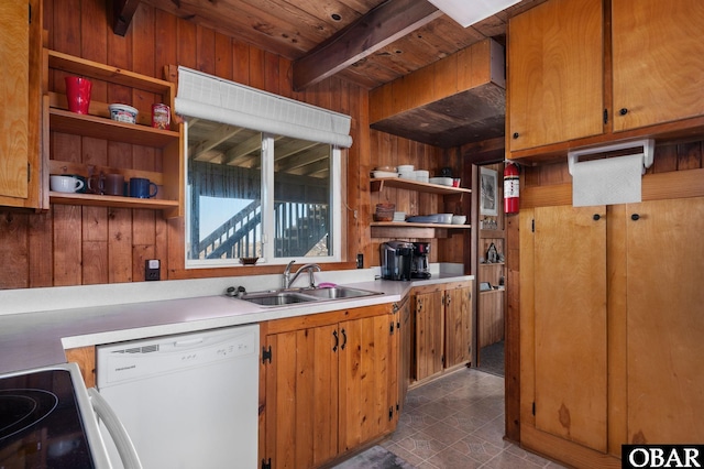 kitchen featuring open shelves, light countertops, wood walls, a sink, and dishwasher