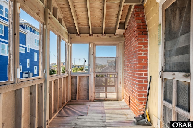 unfurnished sunroom with wood ceiling and beamed ceiling