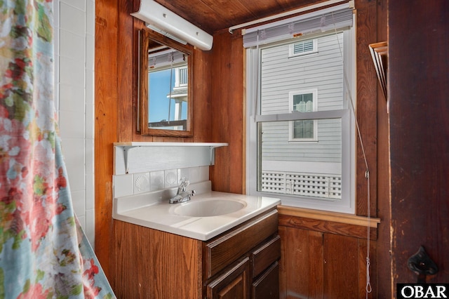 bathroom featuring wood walls, a shower with shower curtain, and vanity