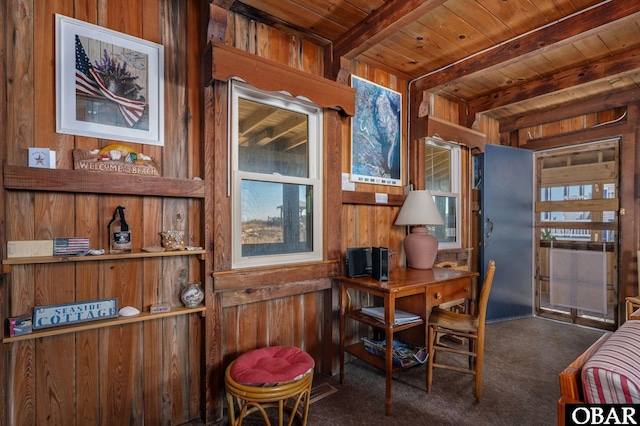 carpeted dining room with wood ceiling, wooden walls, and beam ceiling