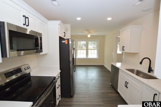 kitchen with appliances with stainless steel finishes, white cabinets, a sink, and visible vents