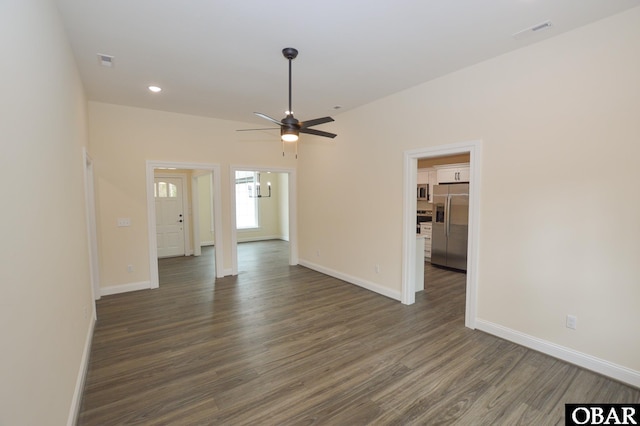 unfurnished room featuring dark wood-style flooring, visible vents, ceiling fan, and baseboards