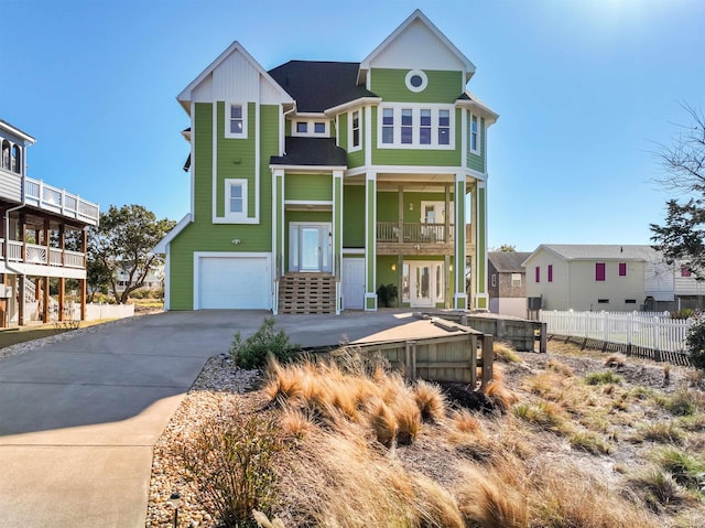 view of front of house featuring concrete driveway, an attached garage, fence, and a residential view