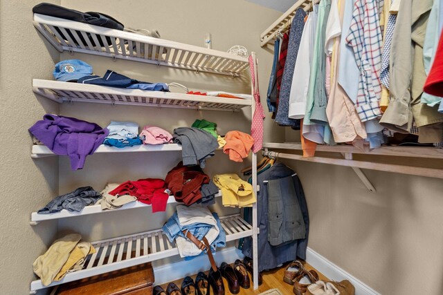 walk in closet with wood finished floors