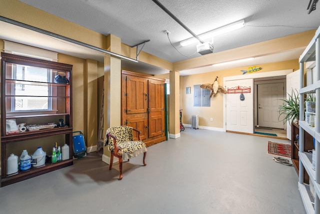 garage featuring a garage door opener, covered porch, and baseboards