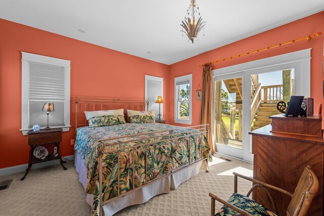 bedroom with access to exterior, baseboards, visible vents, and light colored carpet