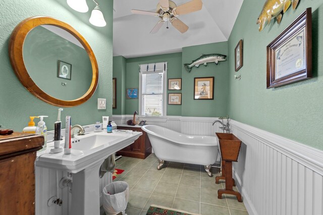 bathroom with a freestanding bath, ceiling fan, wainscoting, and tile patterned floors