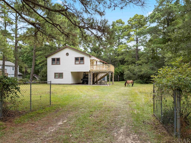 view of yard with driveway, stairway, fence, a deck, and a carport