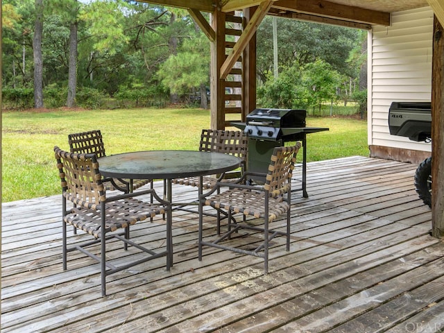 deck with stairway, outdoor dining space, a grill, and a yard