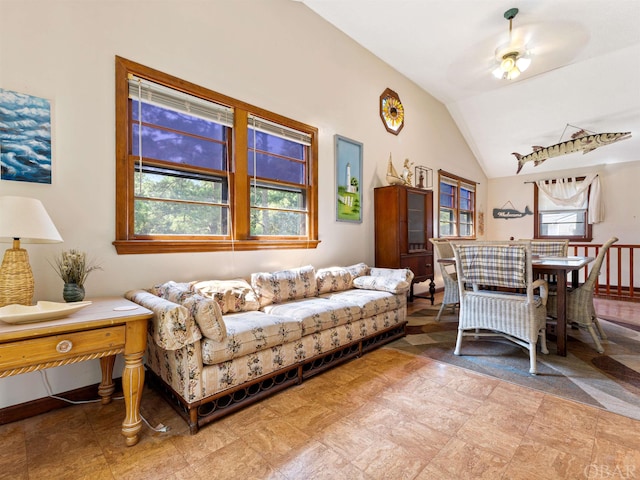 living room with vaulted ceiling, baseboards, a wealth of natural light, and a ceiling fan