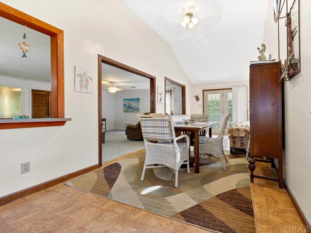 dining area with ceiling fan, baseboards, vaulted ceiling, and french doors