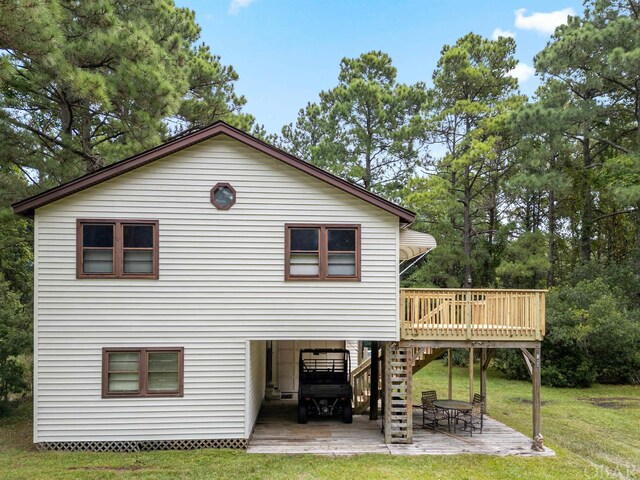 rear view of house featuring a lawn, stairs, a deck, a patio area, and a carport