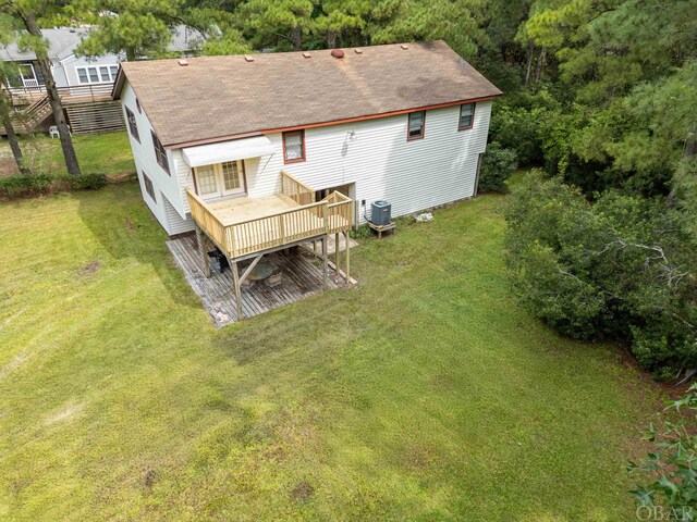 rear view of house with central AC, a yard, roof with shingles, and a wooden deck