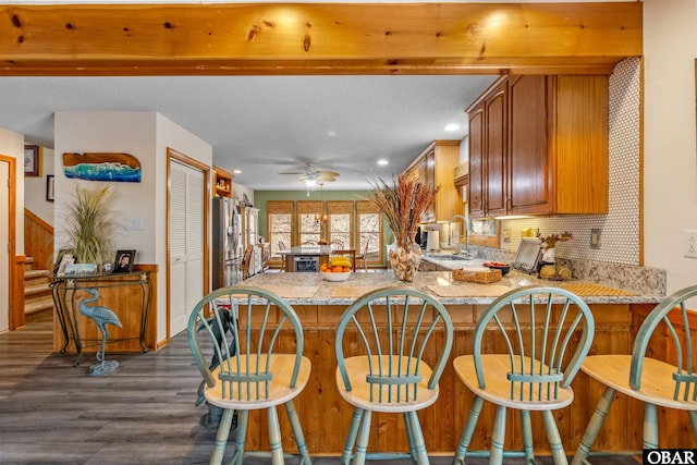119 Baycliff Trl Lot 119, Kill Devil Hills, NC 27948 - kitchen with dark wood-style floors, brown cabinetry, a peninsula, decorative backsplash, and ceiling fan