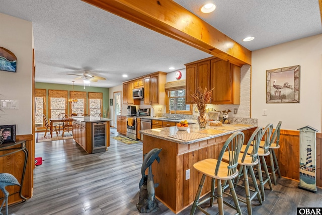 119 Baycliff Trl Lot 119, Kill Devil Hills, NC 27948 - kitchen with appliances with stainless steel finishes, a textured ceiling, beverage cooler, brown cabinetry, and ceiling fan