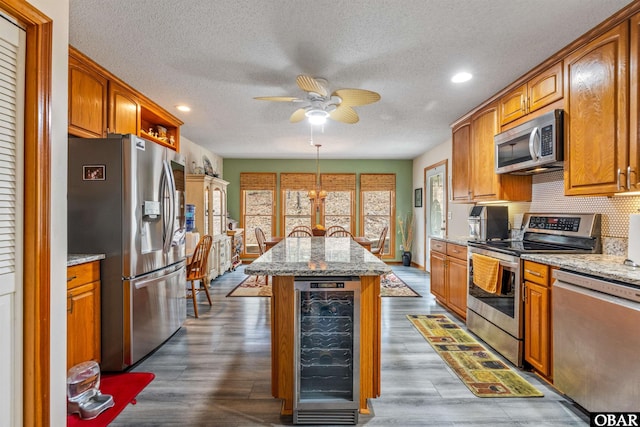 119 Baycliff Trl Lot 119, Kill Devil Hills, NC 27948 - kitchen with appliances with stainless steel finishes, beverage cooler, a textured ceiling, a ceiling fan, and a kitchen island