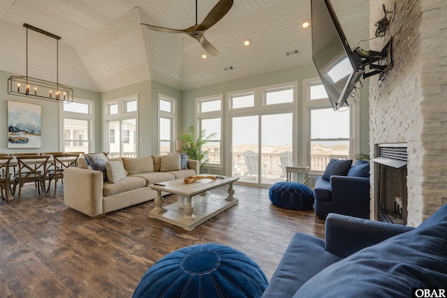 living room featuring high vaulted ceiling, a stone fireplace, visible vents, wood ceiling, and dark wood-style floors