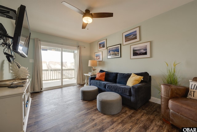living room with dark wood-style flooring, baseboards, and a ceiling fan