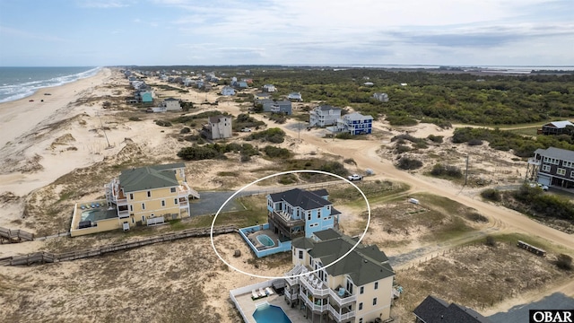 drone / aerial view featuring a water view and a view of the beach