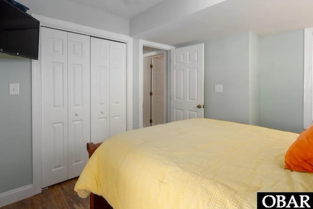 bedroom featuring a closet, baseboards, and dark wood finished floors