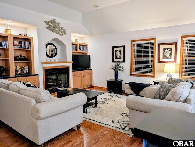 27211 Dory Rd Lot 22, Salvo, NC 27972 - living room with wood finished floors, vaulted ceiling, a fireplace, and built in shelves