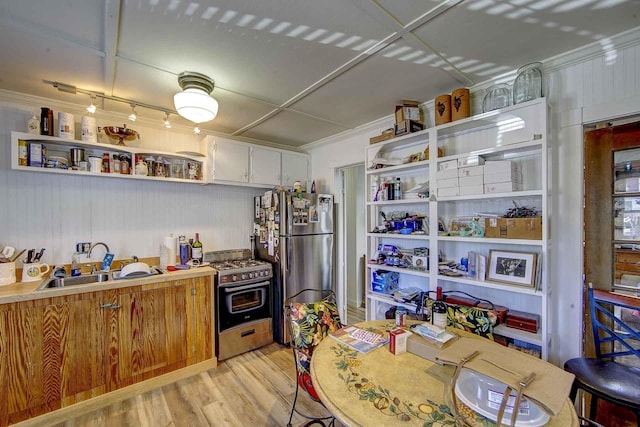 kitchen featuring open shelves, light wood-type flooring, a sink, ornamental molding, and stainless steel appliances