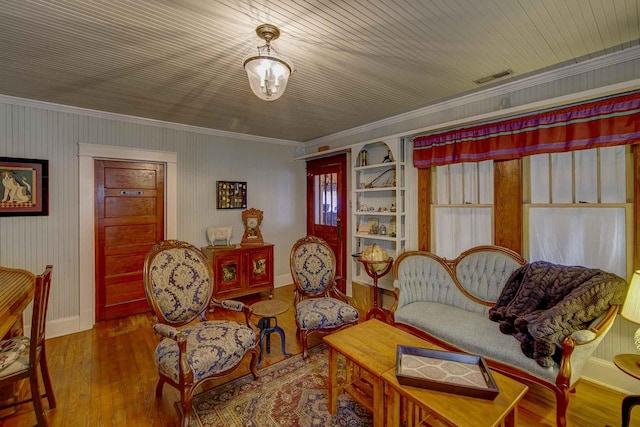 sitting room featuring crown molding, baseboards, wood-type flooring, and visible vents