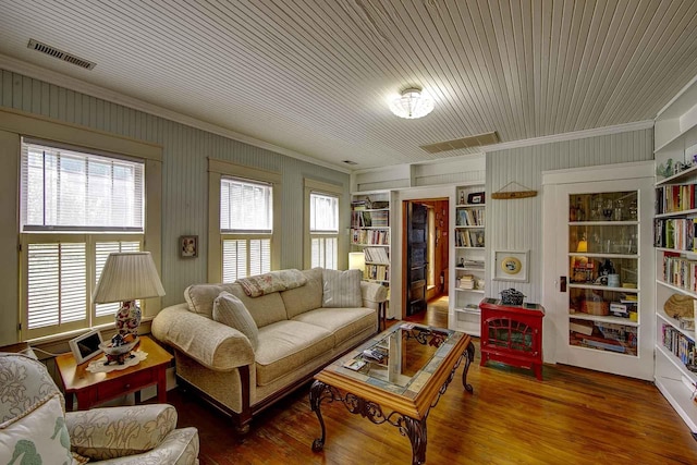 living area featuring visible vents, ornamental molding, and wood finished floors