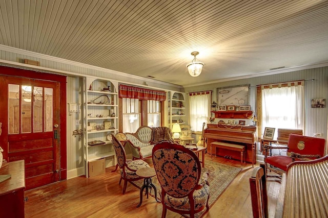 living area featuring crown molding, wood ceiling, built in features, and wood finished floors