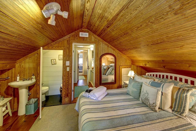 carpeted bedroom with visible vents, wood walls, lofted ceiling, wood ceiling, and connected bathroom