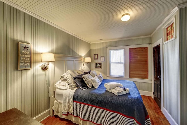 bedroom featuring baseboards, ornamental molding, and wood finished floors