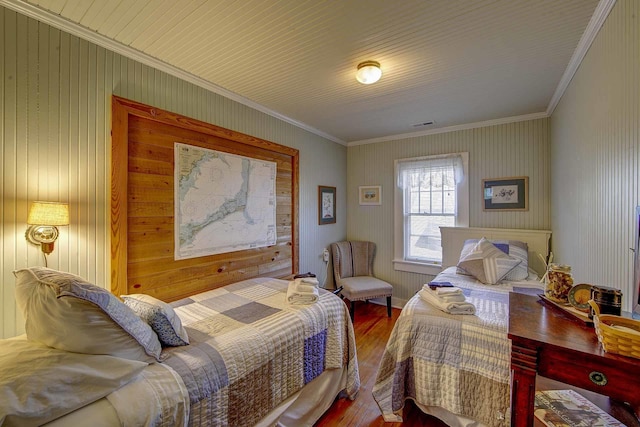 bedroom with crown molding and wood finished floors