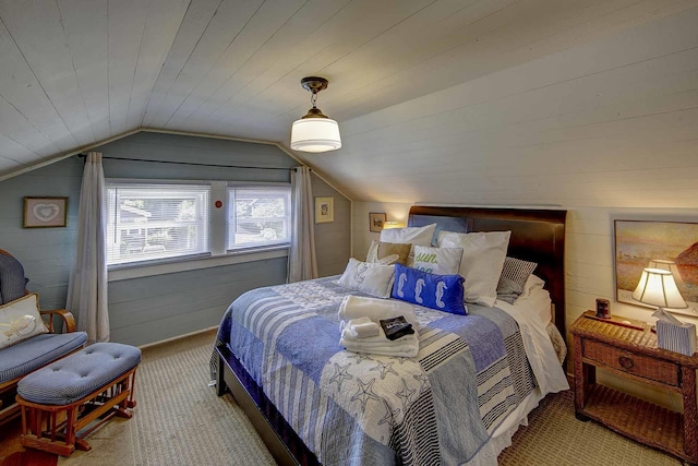 bedroom with carpet flooring, vaulted ceiling, and wood walls