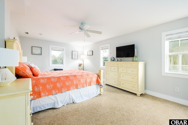 bedroom featuring a ceiling fan, light carpet, and baseboards
