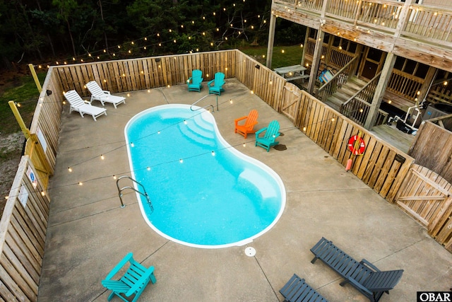 view of swimming pool featuring a deck, a patio, and a fenced in pool