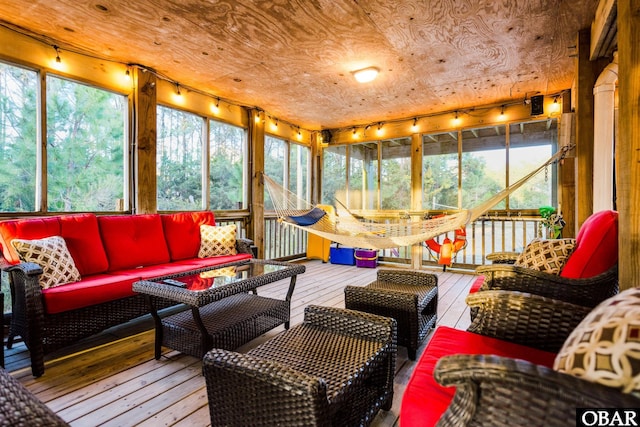sunroom / solarium with an outdoor living space, track lighting, and plenty of natural light