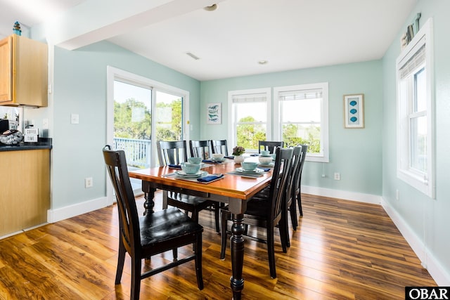 dining area with visible vents, baseboards, a wealth of natural light, and dark wood-type flooring