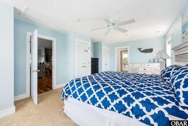 carpeted bedroom with baseboards, visible vents, attic access, and ceiling fan