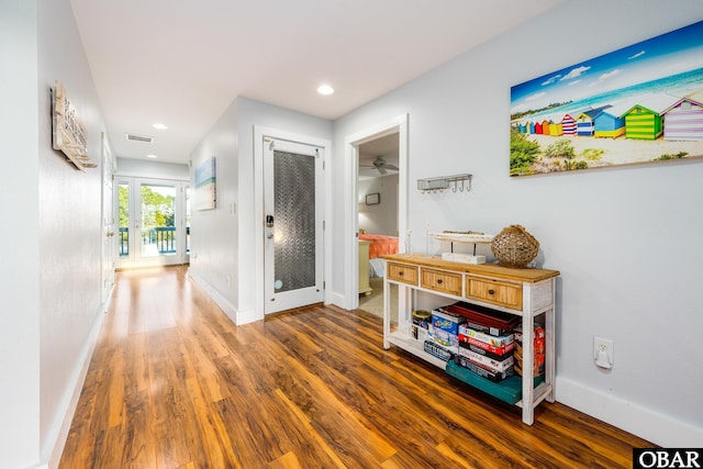 corridor with baseboards, visible vents, wood finished floors, and recessed lighting