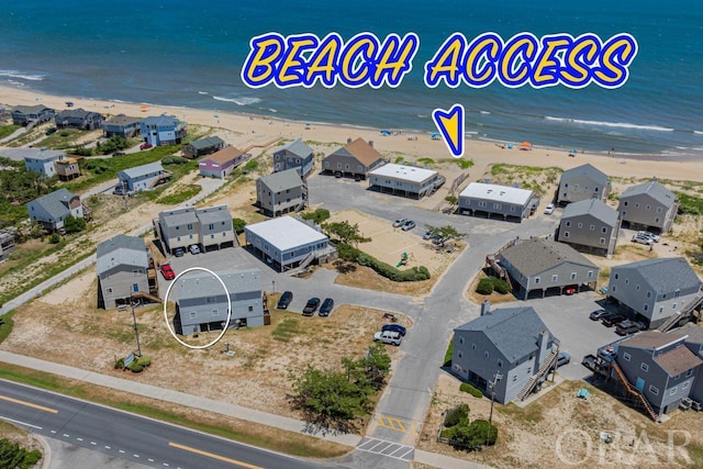 bird's eye view featuring a view of the beach, a water view, and a residential view